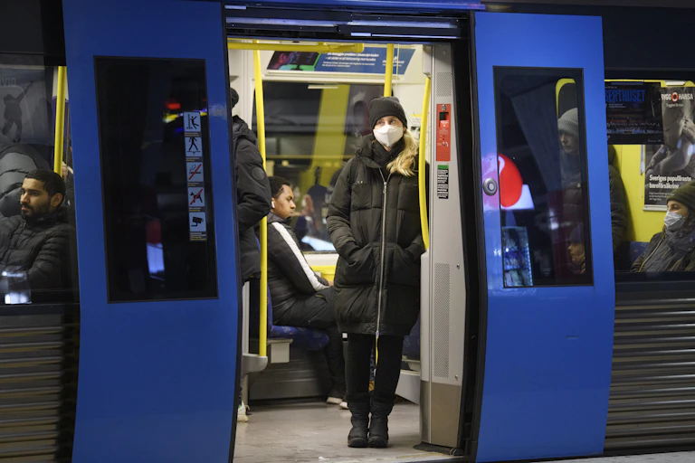 A woman wears a mask on a stockholm train.