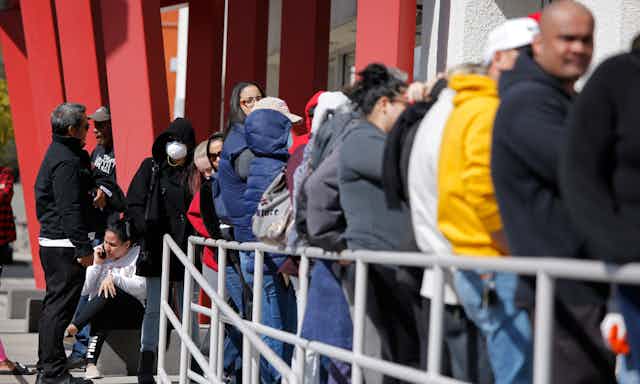 People wait in line for help with unemployment benefits.