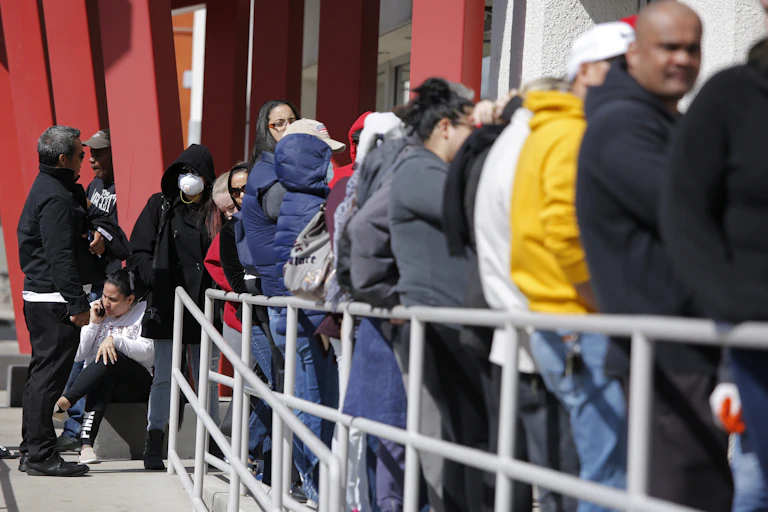 People wait in line for help with unemployment benefits.