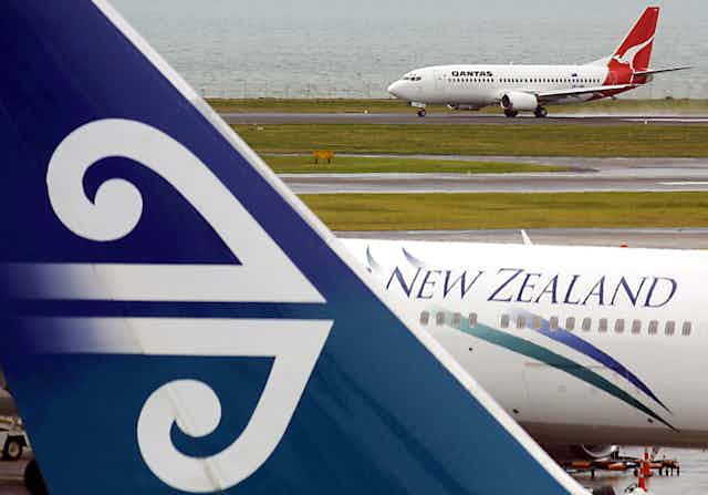 An Air New Zealand passenger plane at Auckland Airport with a Qanta plane in the background