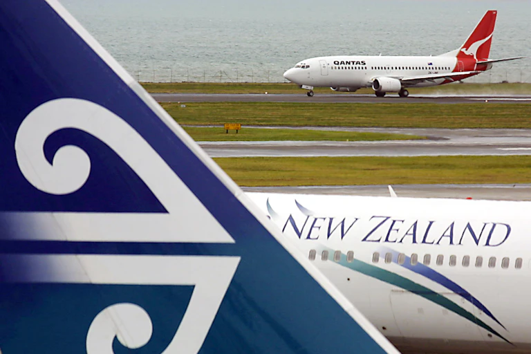An Air New Zealand passenger plane at Auckland Airport with a Qanta plane in the background