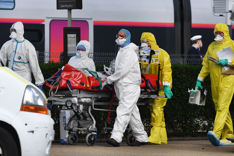 medical staff in PPE gear and patient on gurney
