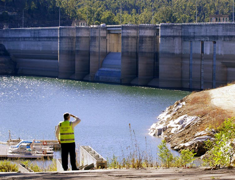 Man stands at dam edge