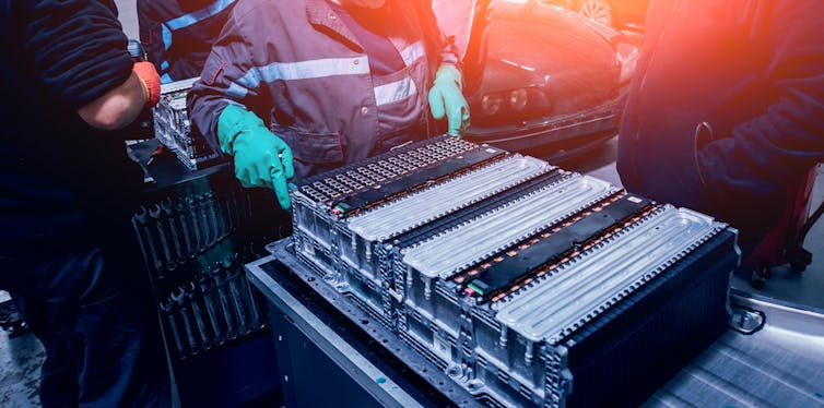 Man inspects an electric vehicle battery