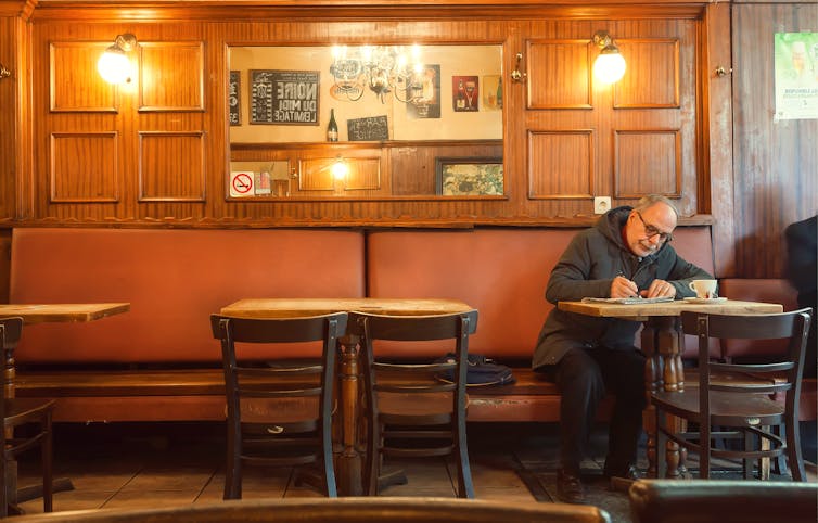 Man drinking alone at a table in a pub