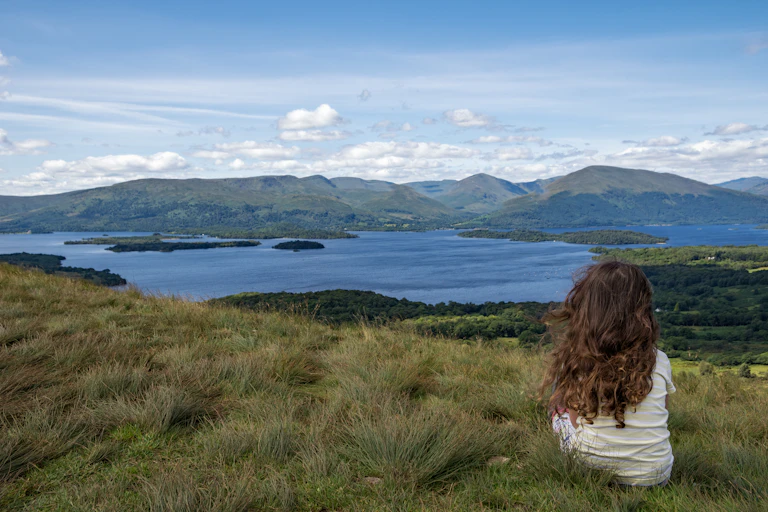 Young girl looks over lake landscape