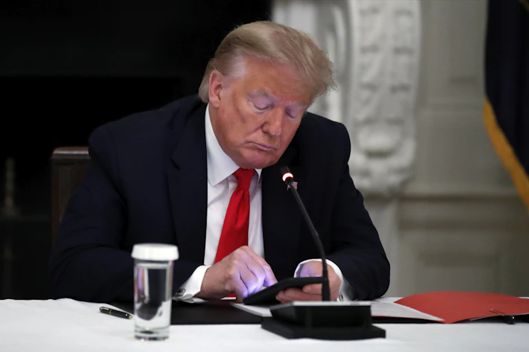 Donald Trump uses his smartphone