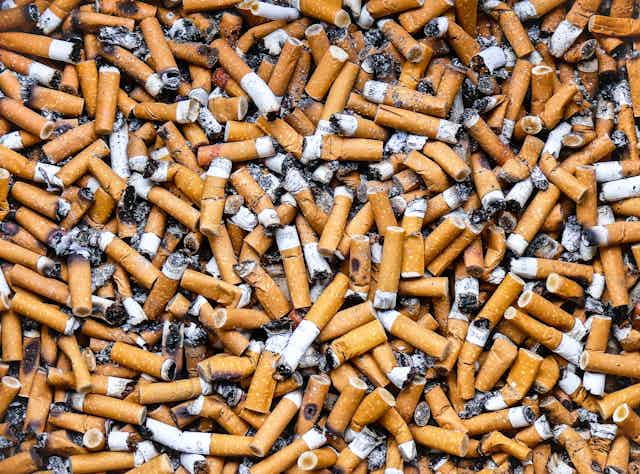 Cigarette butts in a public ashtray.