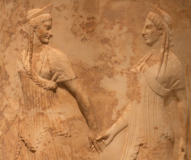 One woman leading another by the hand.