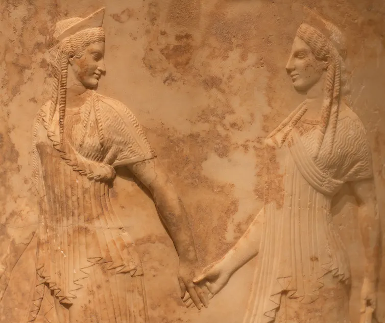 One woman leading another by the hand.