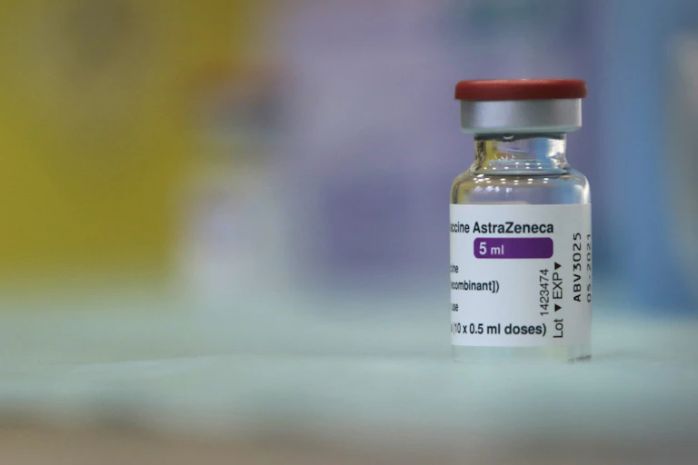 A vial of the AstraZeneca vaccine sits on a table.