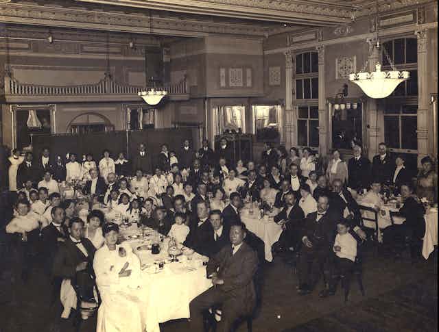 Crowd of men and women at a dinner. 
