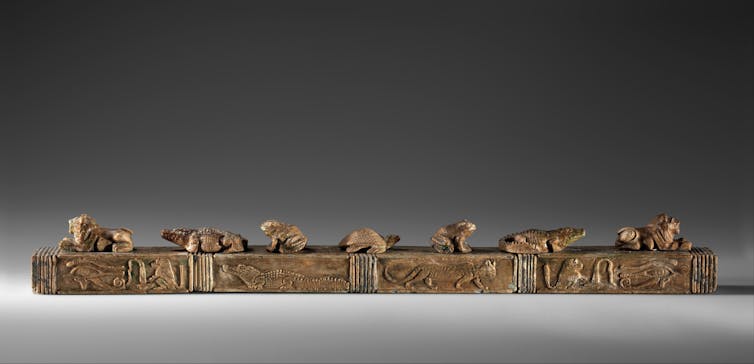 A 'magic wand' decorated with feline predators, crocodiles, toads, a turtle, wedjat eyes, and baboons with flaming torches