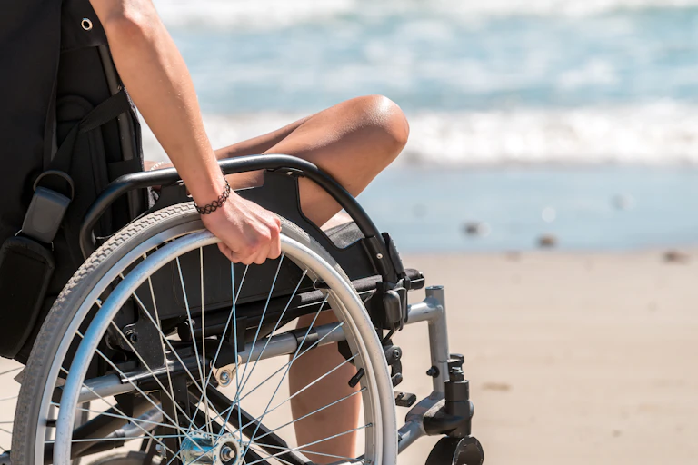 A person in a wheelchair at the seaside.