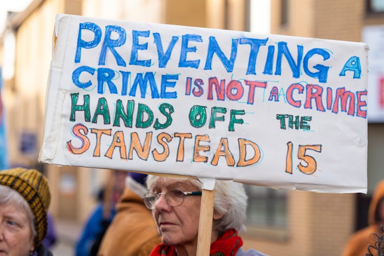 Woman holding protest sign that says