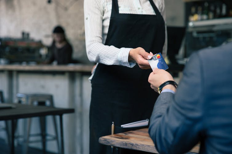 A man paying for a coffee with a debit card