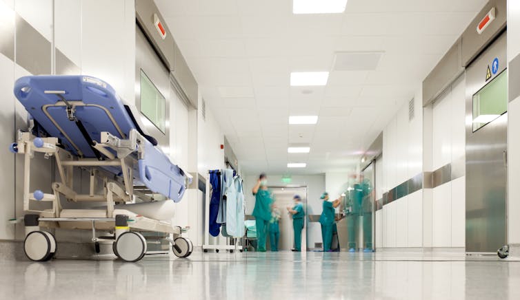 A hospital corridor containing a trolley with staff in the background