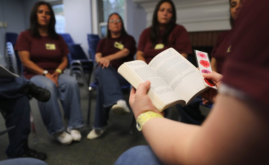 Women prisoners sitting in meeting on addiction. 