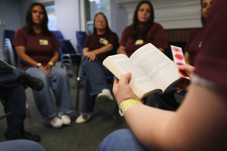 Women prisoners sitting in meeting on addiction.