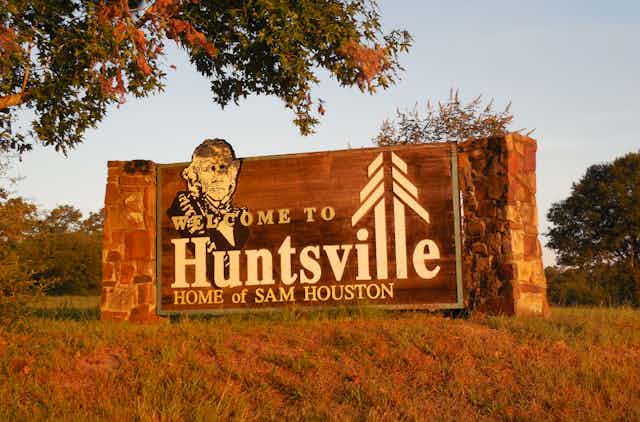 'Welcome to Huntsville, Home of Sam Houston' sign at the entrance of town, featuring the image of Sam Houston 