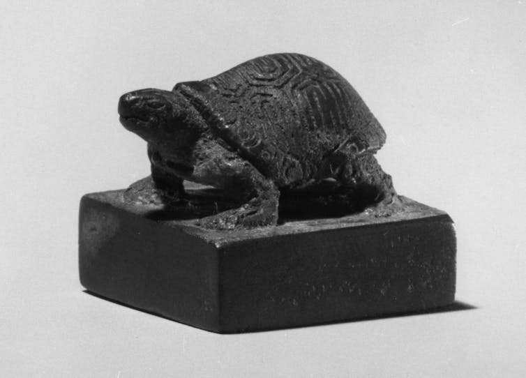 Black sculpture of a tortoise.