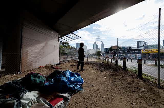 Homeless man looks out at the city from the underpass where he spent the night