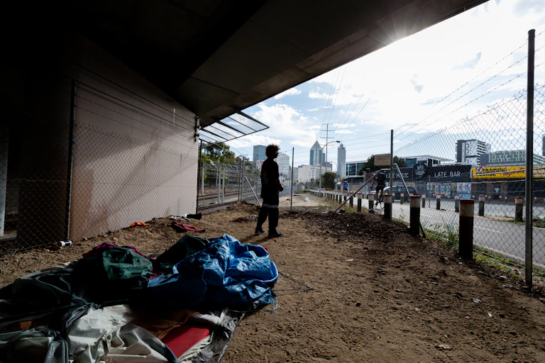 Homeless man looks out at the city from the underpass where he spent the night
