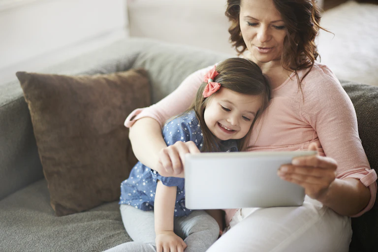 A mother holds a tablet with her child