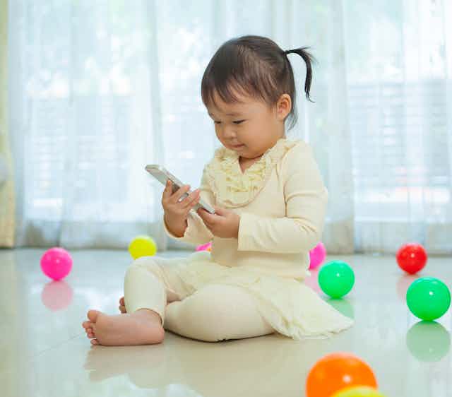 Toddler looking at mobile phone