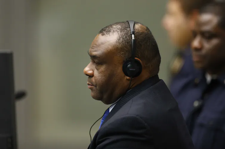 Jean-Pierre Bemba Gombo sits in headphones at the ICC during his war crimes trial.