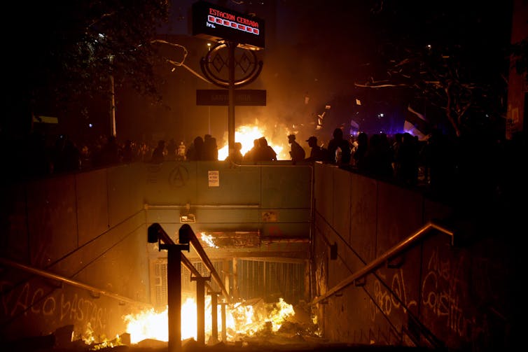 A metro station is set on fire during rioting in the Chilean capital Santiago in 2019.