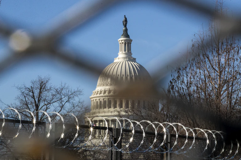 View of the US Capitol with barbed wire in the foreground.