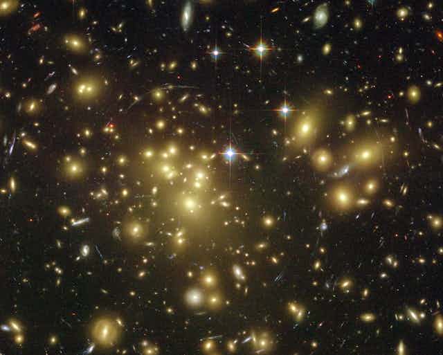 A collection of galaxies captured by the Hubble Telescope showing strong lensing as light is bent into a circular shape.