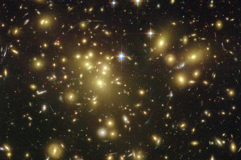 A collection of galaxies captured by the Hubble Telescope showing strong lensing as light is bent into a circular shape.
