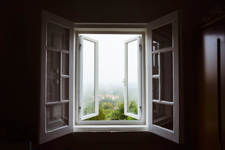 Open windows looking onto the foggy countryside.
