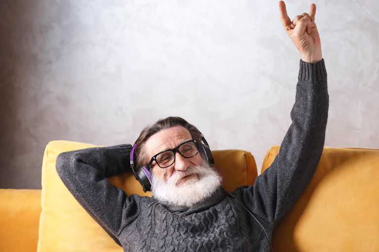 Image of senior man listening his favorite rock music song, modern technology