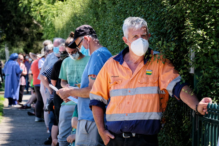A queue of people await COVID testing in Melbourne.