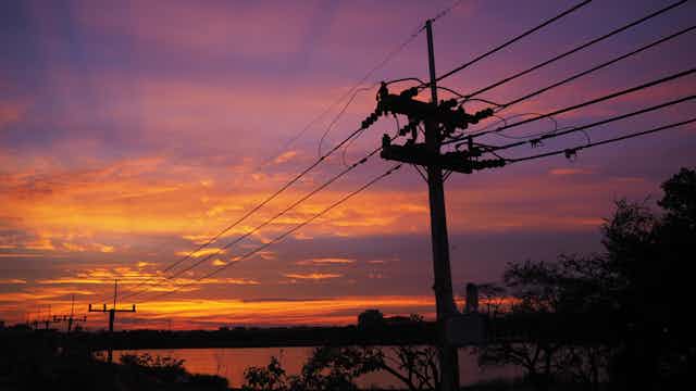 Power lines illuminated by the sunrise.