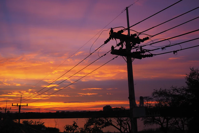 Power lines illuminated by the sunrise.