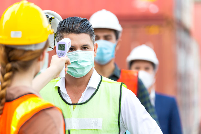 Builders having the temperature checked using an infrared scanner