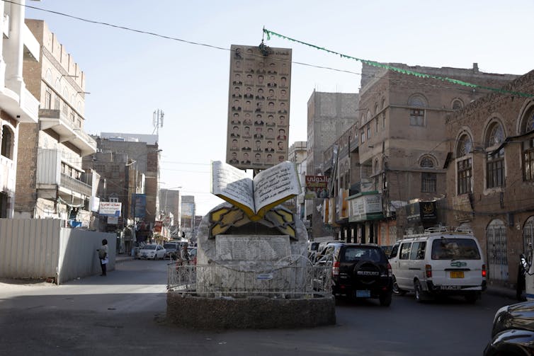 Cars drive past a memorial to the dead of the Yemen civil war in the capital Sana'a, January 2021.
