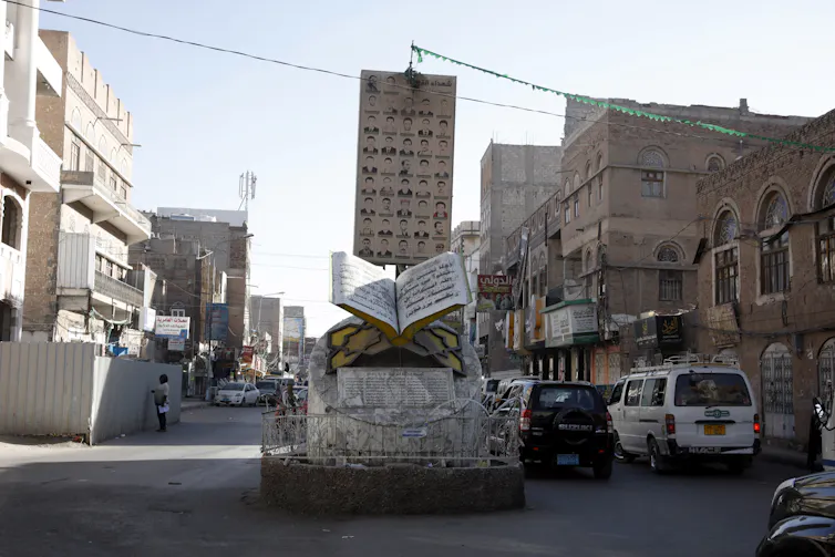 Cars drive past a memorial to the dead of the Yemen civil war in the capital Sana'a, January 2021.