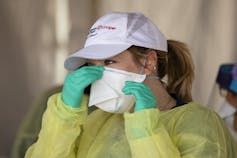 Woman pinching nose of mask checking for good fit