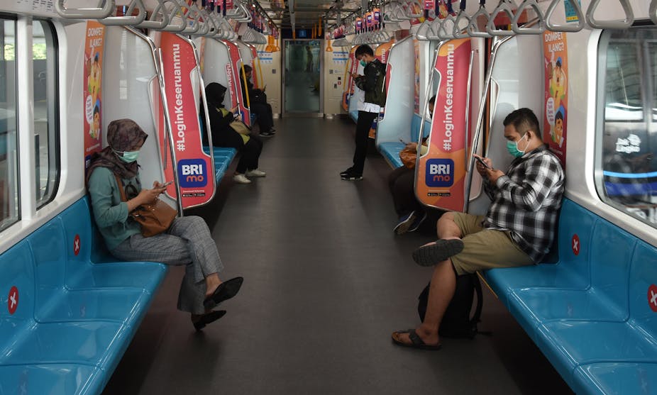 Penumpang duduk dengan menjaga jarak di dalam kereta MRT di Stasiun MRT Blok M, Jakarta.