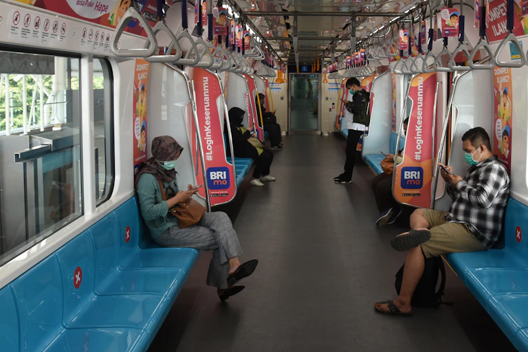 Penumpang duduk dengan menjaga jarak di dalam kereta MRT di Stasiun MRT Blok M, Jakarta.