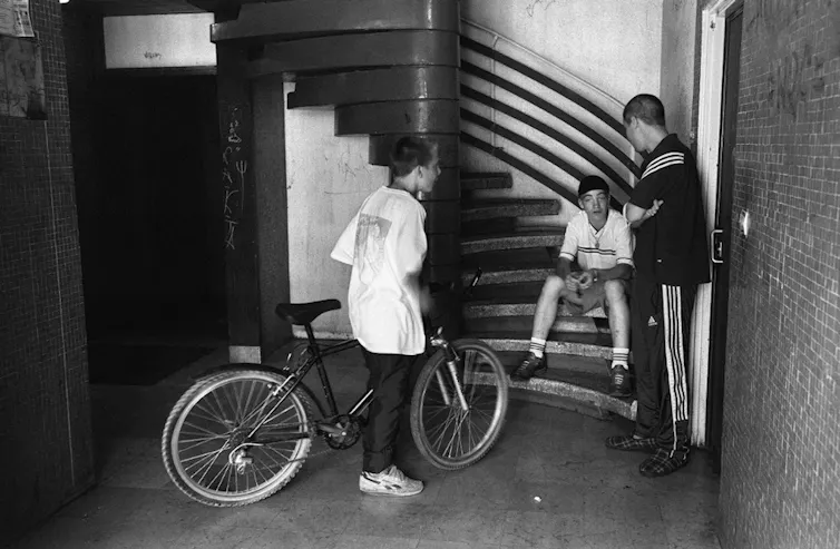 Des jeunes dans le hall d'un immeuble de la cité de la Grande Borne à Grigny, en juillet 2002.