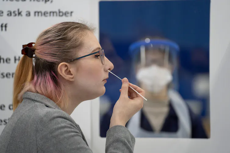 A person swabbing their nose for COVID.