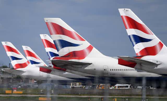 The tails of five British Airways planes in a row.