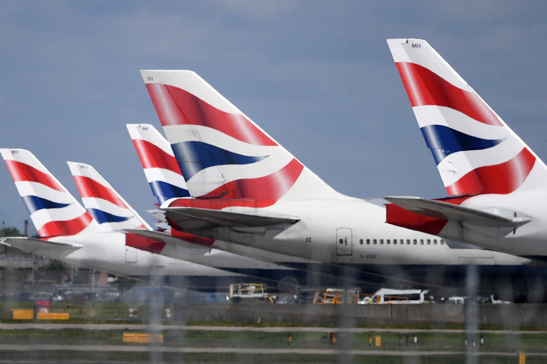 The tails of five British Airways planes in a row.