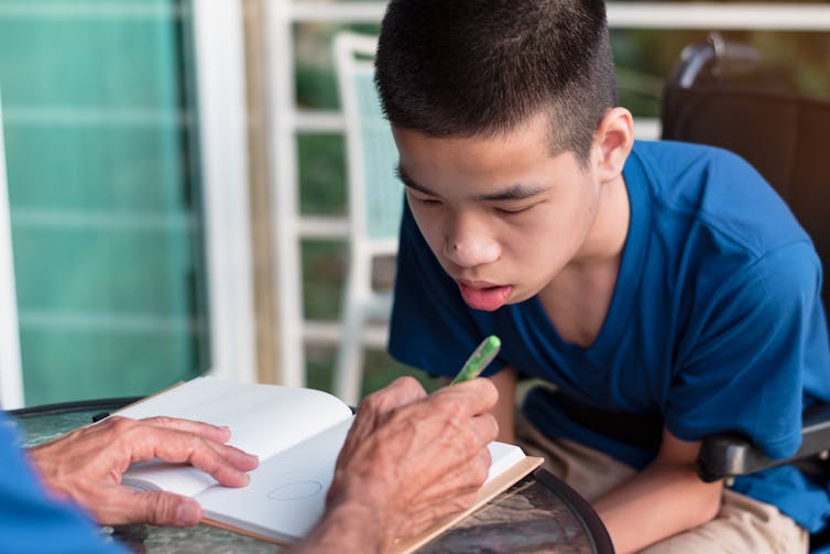 Adult teaching child with special educational needs.